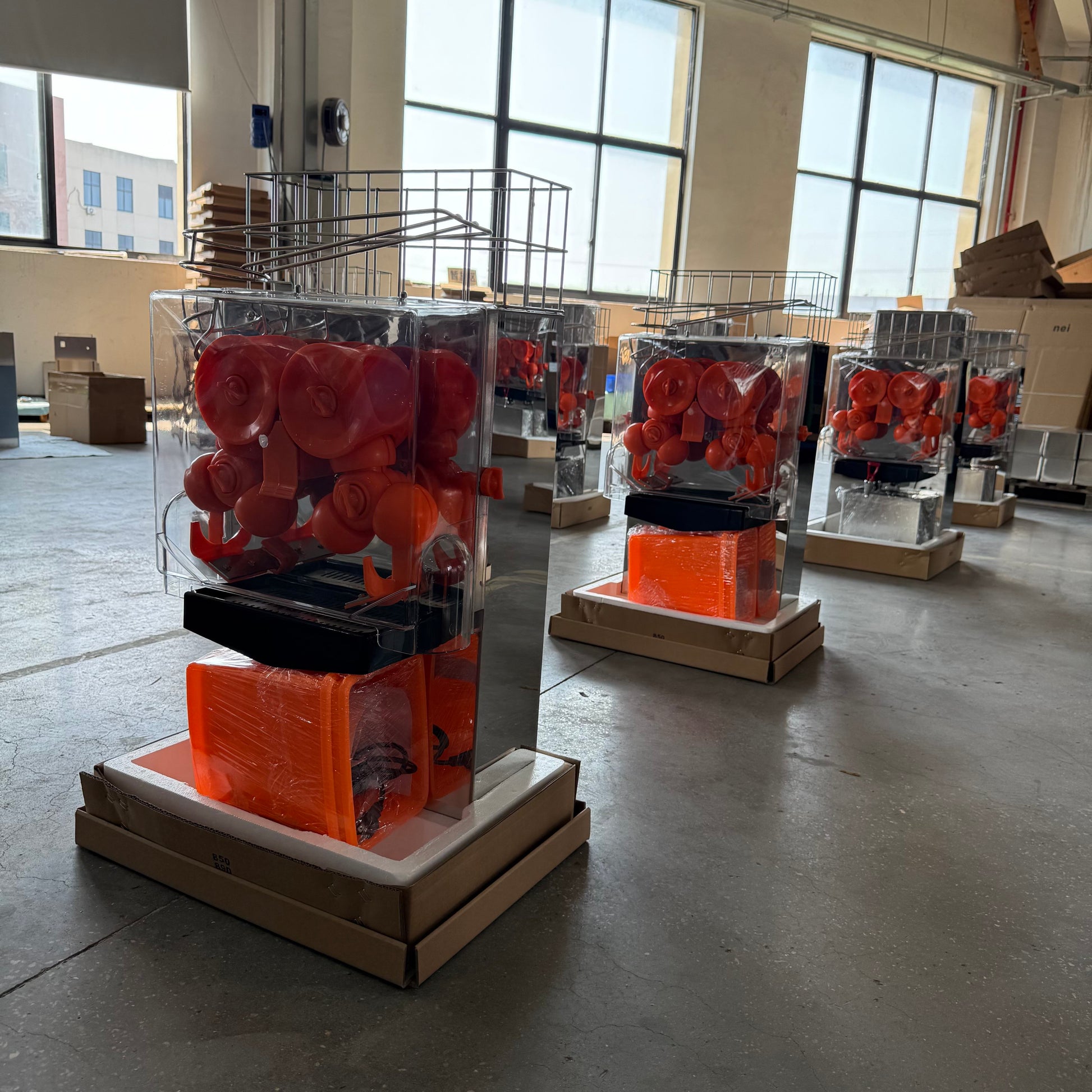 Commercial orange juicer machine with orange rollers inside clear protective housing